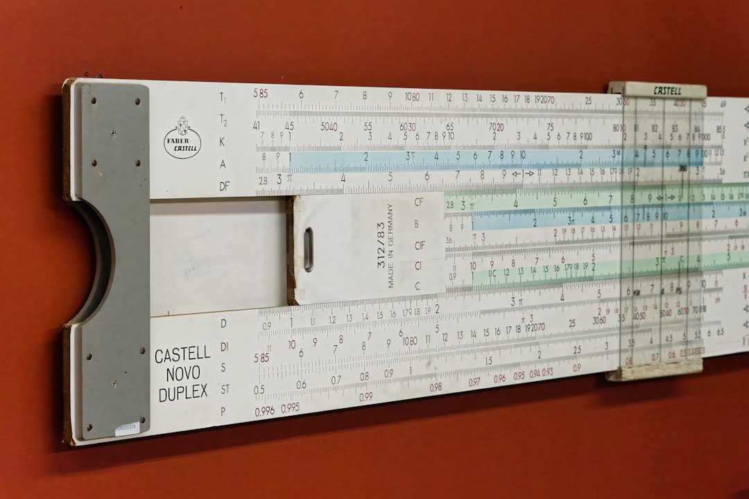 Vintage slide rule from the early 20th century displayed on a wall, showcasing mathematical calculations and engineering design - A vintage slide rule rests against a rust-colored wall, revealing scales and markings used for mathematical calculations in engineering during the 20th century. by ChatBench.org A large ruler mounted to the side of a wall